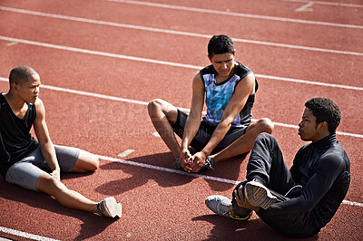 Buy stock photo Shot of young athletes sitting together on the track