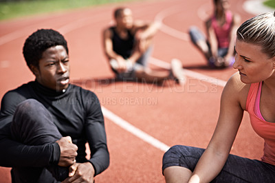 Buy stock photo Shot of young athletes sitting together on the track