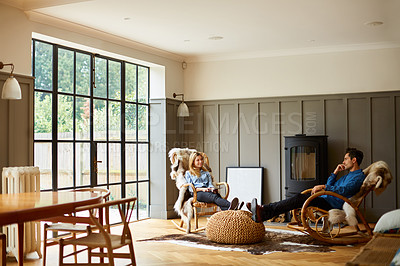 Buy stock photo Shot of a couple relaxing together on rocking chairs at home