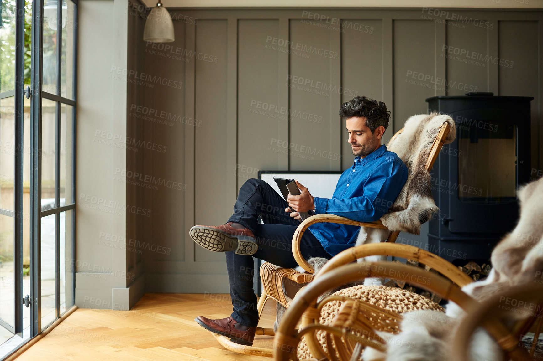 Buy stock photo Man, relax and reading in living room with tablet, ebook and internet connectivity for online story. Calm, person and chill in home with comfortable chair, digital tech or browsing website for novel.