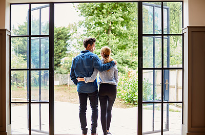 Buy stock photo Rearview shot of a couple looking at the view outdoors from their home
