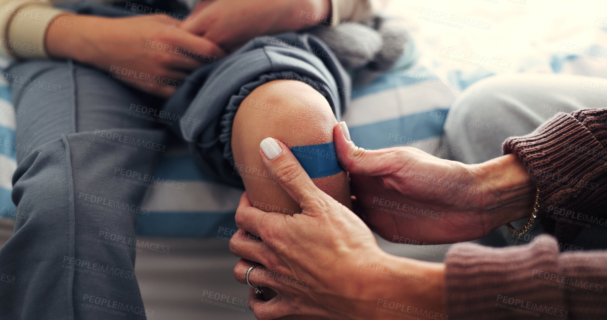 Buy stock photo Child, injury and hands with plaster in house, parent and treatment for knee pain or help for bruise. Healthcare, home and person with bandage for wound, comfort and assistance for kid after accident