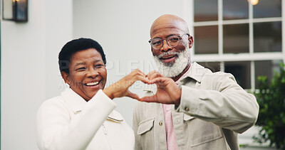 Buy stock photo New house, smile and couple with heart hands, love sign and support with property investment. Mature black people, portrait and care gesture with security, real estate and connection at backyard