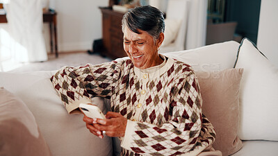 Buy stock photo Text, phone and elderly woman in home with laugh, online communication and comic post on social media. Happy, digital and senior person on sofa with tech, funny message or meme reaction on chat app.