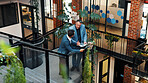 People, discussion and tablet in office with sustainability audit, carbon footprint report or research. Above, men and talk on stairs with tech, eco friendly business and collaboration for ESG goals.