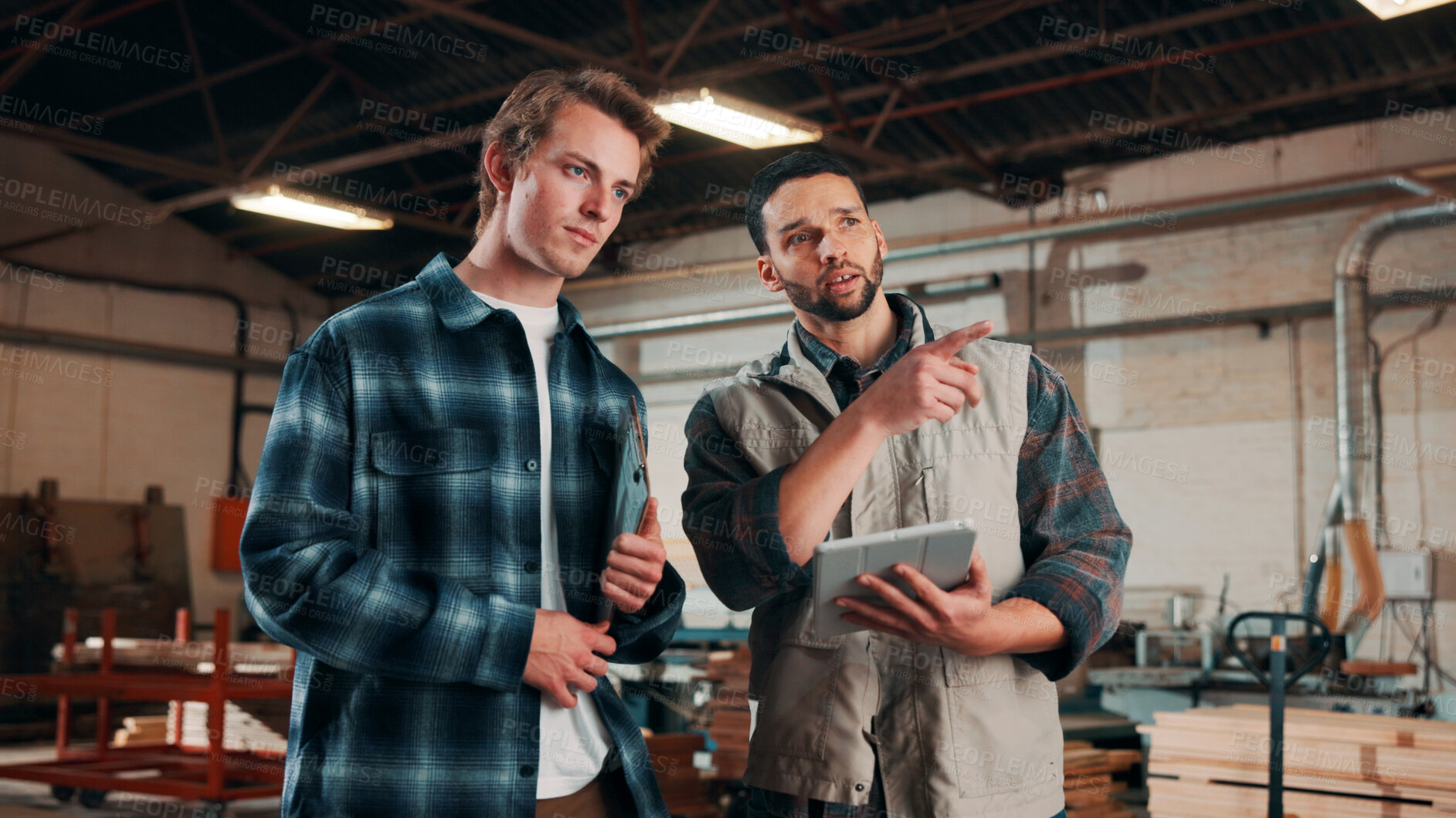 Buy stock photo Men, tablet and meeting in lumber workshop, carpenter and apprentice with discussion for advice in woodwork. Point, talk and supervisor with trainee, tech and team guidelines for carpentry planning