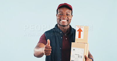 Buy stock photo Portrait, boxes and delivery man in studio with thumbs up, postal service and online shopping package. Happy, black person and courier with ecommerce order, like emoji and space on blue background.