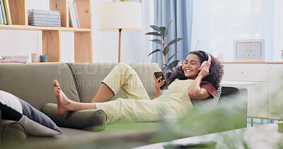 Buy stock photo Headphones, happy and woman on sofa with phone for music subscription, internet and track on weekend. Relax, home and person with audio, radio and mobile app for social media, good mood and break