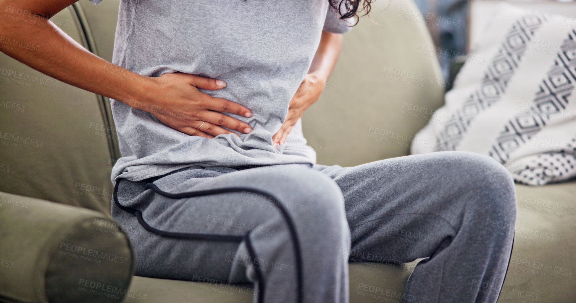 Buy stock photo Hands, pain and woman with stomach ache on sofa for menstruation, discomfort or PMS crisis. Endometriosis cramps, person and belly indigestion in home from ovulation cycle, IBS or abdominal bloating