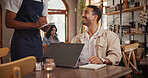 Laptop, order and waiter with man in restaurant for menu option, freelancer and lunch break. Smile, cafe and remote worker with customer in coffee shop for drinks request, hospitality and tech