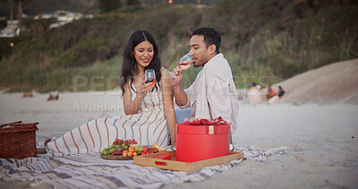 Buy stock photo Love, picnic or couple at beach with wine glass, holiday together or bonding on anniversary celebration. Happy, fruit or people with alcohol, partner connection or special moment on outdoor honeymoon