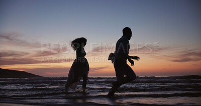 Buy stock photo Silhouette, couple and running at beach for travel, journey and romantic date on holiday. Space, sunset and people at seashore with happiness, commitment and tropical vacation for adventure getaway