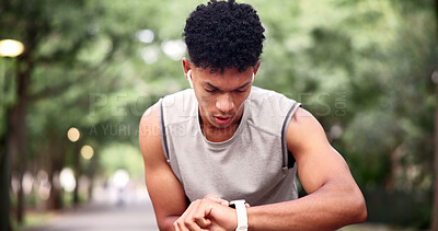 Buy stock photo Fitness, man and outdoor with smart watch for time, tracking distance and change music with earphones. Runner, tech and timer in nature to monitor cardio, notification and select audio on break