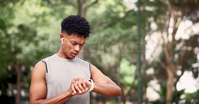 Buy stock photo Fitness, man and smart watch in nature for time, tracking distance and change music with earphones. Runner, tech and outdoor with timer to monitor cardio, notification and select audio on break
