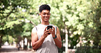 Fitness, earphones and man with phone at park, online and texting with smile on social media or chat. Happy, athlete and person with mobile for workout update, message and listening to music on break