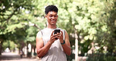 Buy stock photo Fitness, earphones and man with phone at park, online and texting with smile on social media or chat. Happy, athlete and person with mobile for workout update, message and listening to music on break