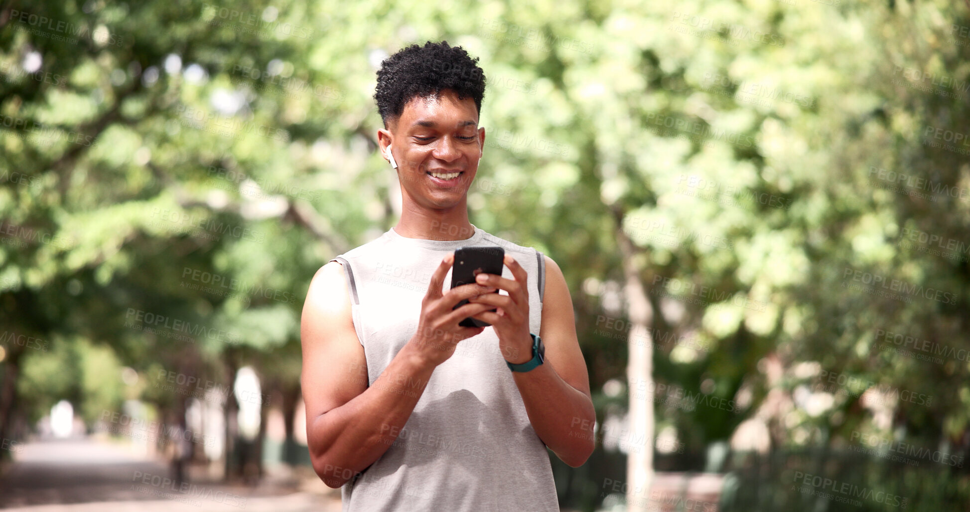 Buy stock photo Fitness, earphones and man with phone at park, online and texting with smile on social media or chat. Happy, athlete and person with mobile for workout update, message and listening to music on break
