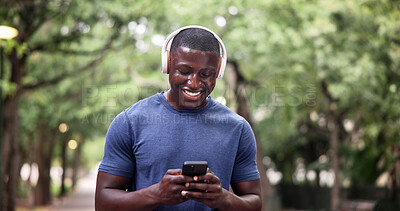 Buy stock photo Fitness, headphones and man with phone in nature, online and texting with smile on social media app. Happy, athlete and black person with mobile for workout update, message and listening to music