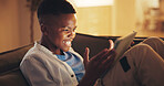 Excited, tablet and gamer with black child on sofa in home for esports app, streaming service and night. Online gaming platform, relax and entertainment with kid in living room of apartment for hobby
