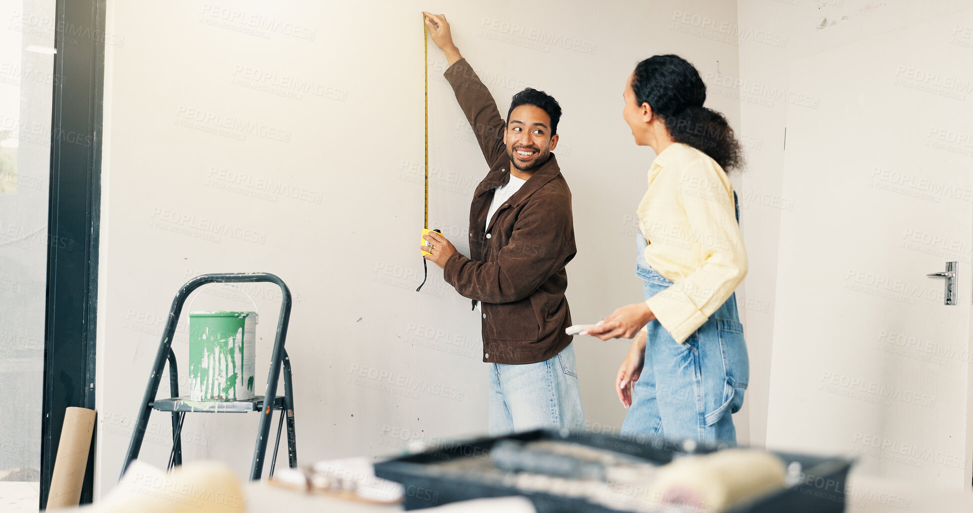 Buy stock photo Measuring, tape and couple in new home for repairs, maintenance or property development. Tool, real estate and man with woman for precision on wall for construction renovation in apartment together.