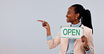 Pointing, space and black woman with open sign in studio for business welcome, advertising or marketing. Happy, poster and employee with options, menu or list for service on white background.
