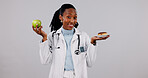 Happy, doctor and portrait with diet choice in studio for healthy option on a white background. Female person, healthcare worker or smile with donut, fruit or apple for vitamins, nutrition or dessert