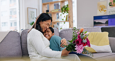 Buy stock photo Gift, flowers and mother with girl on couch for smile, gratitude and care or love in living room. Happy mom, daughter and hug for birthday bouquet, celebration or present for surprise in family house