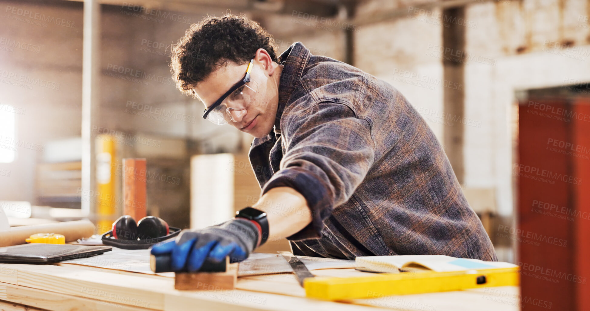 Buy stock photo Carpenter, sanding and man in workshop with wood for manufacturing, productivity and production. Person, safety gear and warehouse with tools for custom or handmade woodworking, workbench and timber