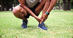 Park, person and ankle pain with hands, fitness and grass field for exercise and workout with muscle tension. Man, athlete and runner with accident, overworked joint and burnout from training