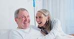 Senior, laughing and happy couple in nursing home for healthcare, funny joke or humor together. Elderly, man and woman with smile or hug in bed for comedy, support or trust in retirement house