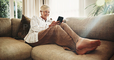 Buy stock photo Laugh, sofa and senior woman with phone, social media and funny message for internet connection. Retirement, home and happy person on cellphone for contact, online humor and website in living room