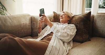 Buy stock photo Relax, sofa and senior woman with phone, social media and online message for internet connection. Retirement, home and happy person on cellphone for contact, digital puzzle and website in living room