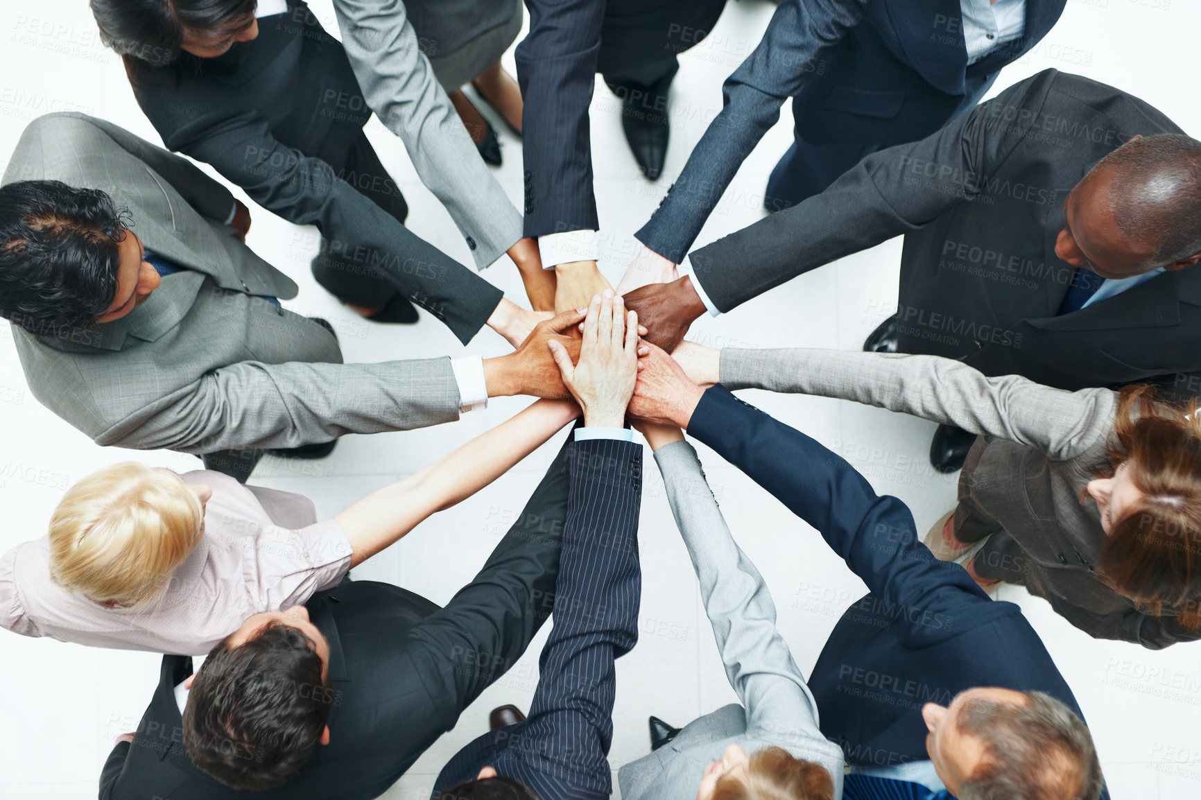 Buy stock photo Above, huddle and business people in studio with hands together, diversity or unity for collaboration. Employees, teamwork and solidarity for corporate goals, synergy and support on white background.