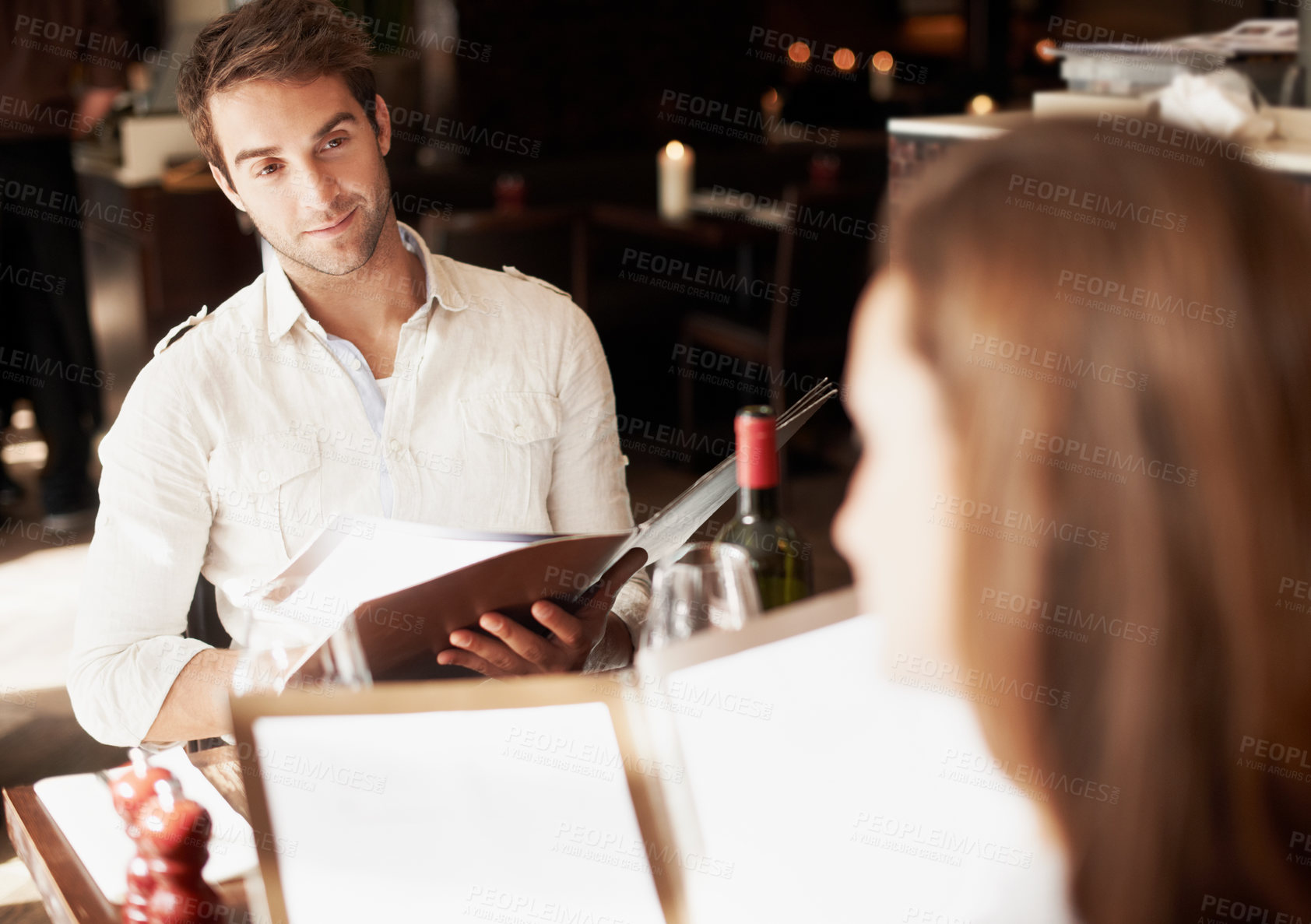 Buy stock photo Man, date and reading menu at restaurant with choice, care and option on valentines day. Couple, love and together for connection, anniversary or dining with list, wine bottle and relationship