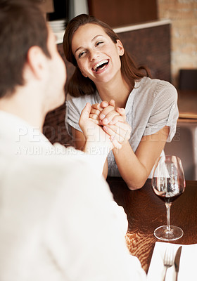 Buy stock photo Couple, laugh and holding hands in restaurant with wine, love and funny joke for bonding together. Happy people, date and romantic relationship in diner with alcohol drink, humor and commitment.