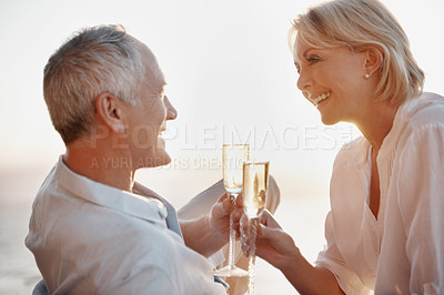 Buy stock photo Couple, happy and cheers at ocean with champagne, celebrate milestone and travel with love. Mature people, smile and toast with drink for bonding, relationship appreciation and commitment at beach