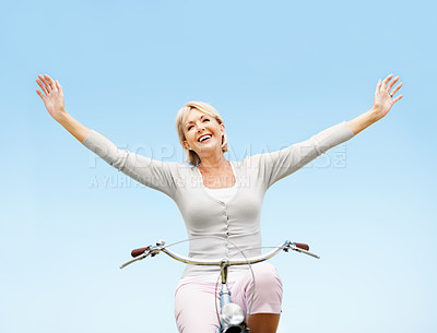 Buy stock photo Sky, freedom and happy woman on bicycle, travel and adventure with eco friendly transport or outdoor. Mockup space, low angle and mature person with smile, cycling and bike with zero carbon emissions