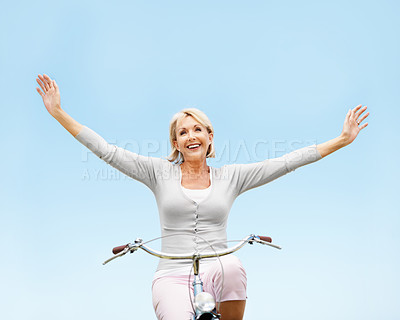 Buy stock photo Outdoor, sky and happy woman on bicycle, freedom and adventure with eco friendly transport or travel. Mockup space, low angle and mature person with smile, cycling and bike with zero carbon emissions