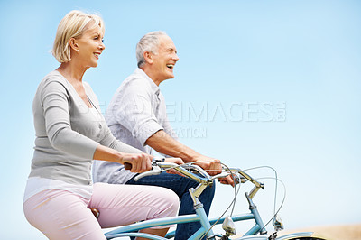 Buy stock photo Love, cycling and laugh with old couple in nature for bonding, weekend break and anniversary vacation. Retirement, holiday and travel with senior man and woman on bicycle outdoor for joke and space