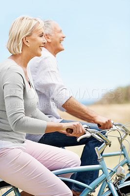Buy stock photo Love, cycling and funny with old couple in nature for bonding, weekend break and anniversary vacation. Retirement, holiday and space with senior man and woman laughing on bicycle outdoor for marriage