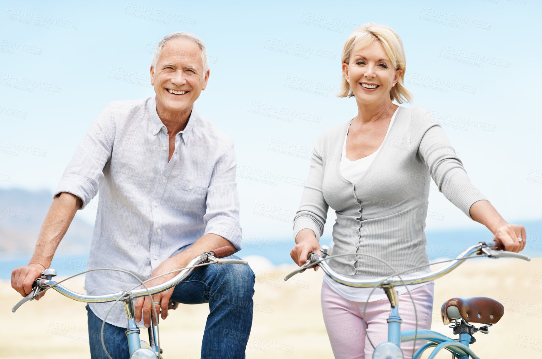 Buy stock photo Beach, bicycle and vacation with senior couple, portrait and smile with transportation for travel. Happy man, woman and bike outdoor for cycling, health and active retirement for wellness on holiday