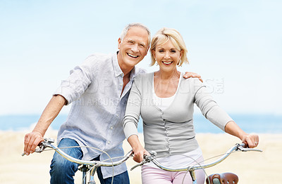 Buy stock photo Portrait, bicycle and mature couple by ocean for bonding on vacation, holiday and summer weekend. Happy, embrace and man with woman on bike for travel, eco friendly transport and relax by seaside