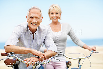 Buy stock photo Happy, portrait and senior couple on bike outdoor on vacation, getaway or weekend trip together. Smile, blue sky and elderly man with woman on bicycle for cycling, bonding or adventure on holiday.