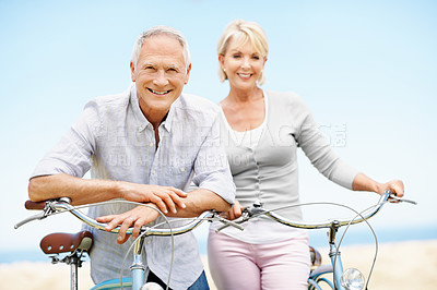 Buy stock photo Bonding, portrait and senior couple on bicycle outdoor on vacation, getaway or weekend trip together. Happy, blue sky and elderly people on bike for cycling, connection or adventure on holiday.