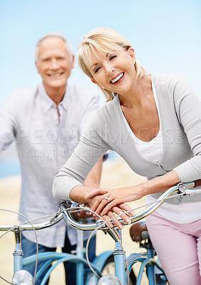 Buy stock photo Happy, portrait and couple on bicycle outdoor on vacation, getaway or weekend trip together. Smile, blue sky and mature man with woman on bike for cycling, bonding or adventure in marriage on holiday