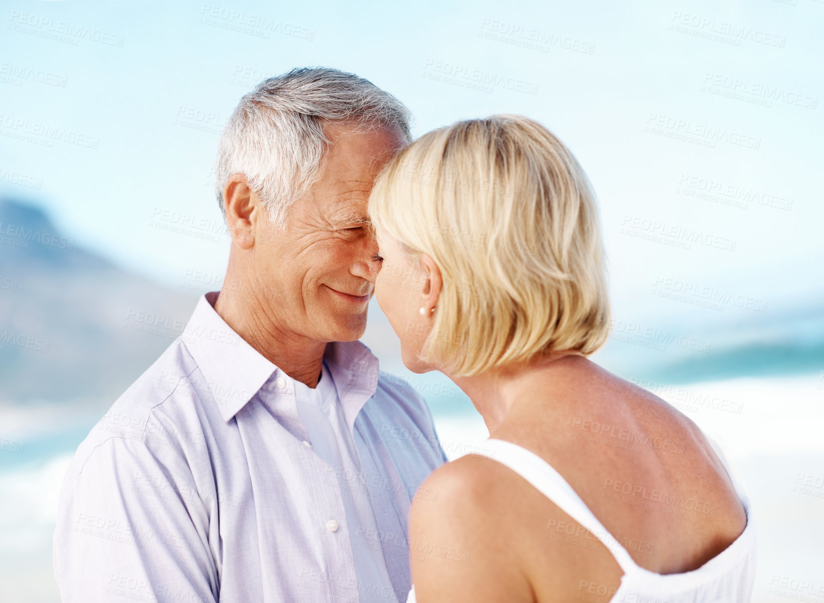 Buy stock photo Holiday, smile or elderly couple at beach with love, happy moment or connection on vacation. Trust, partner or senior people with forehead touch, romantic relationship or bonding on outdoor getaway.