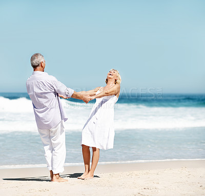 Buy stock photo Holding hands, laugh and mature couple at beach for bonding, marriage and playful relationship. Travel, happy and man with woman by ocean for summer holiday, vacation and anniversary for connection