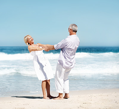 Buy stock photo Holding hands, happy and mature couple by ocean for bonding, marriage and playful relationship. Travel, smile and man with woman at beach for summer holiday, vacation and anniversary for connection