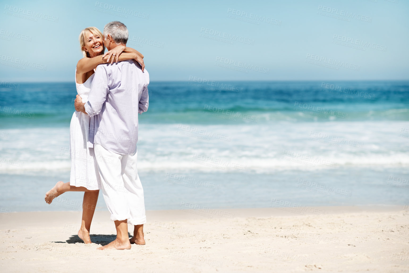 Buy stock photo Support, hug and couple by beach with love on summer vacation, getaway or weekend trip together. Smile, space and mature woman embracing man with safety, bonding or connection by ocean on holiday.