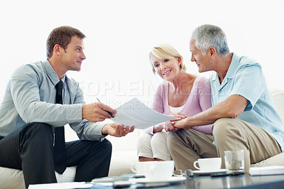 Buy stock photo Senior, couple and agent with paperwork in meeting for housing options, mortgage equity or explain. Realtor, happy people and forms in home for retirement planning, estate agreement and transfer deed